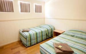 a room with two beds and a table and windows at Tasman Holiday Parks - Kalbarri in Kalbarri