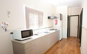uma cozinha com um lavatório, um micro-ondas e um frigorífico em Tasman Holiday Parks - Kalbarri em Kalbarri