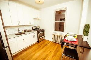 a kitchen with white cabinets and a wooden floor at Urban Bedroom in Mount Vernon