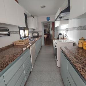 a large kitchen with white cabinets and granite counter tops at CASA RURAL ALEGRÍA in Caudete de las Fuentes