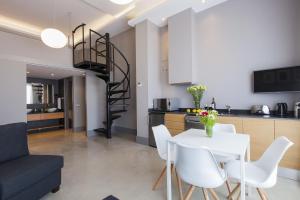 錫切斯的住宿－Kare No Apartments by Sitges Group，厨房以及带白色桌椅的用餐室。
