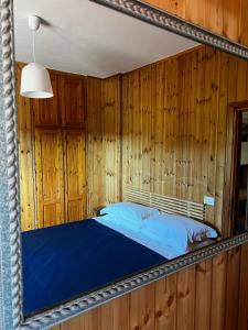 a mirror reflecting a bed in a room with wooden walls at Bed 100s in Livata