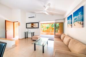 een woonkamer met een bank en een glazen tafel bij Hotel Ixzi Plus in Ixtapa