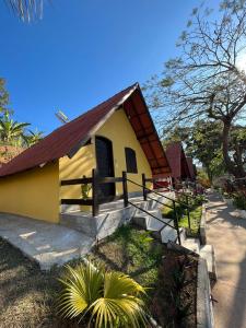 a small yellow house with a red roof at Pousada 2 Baioco in Paty do Alferes