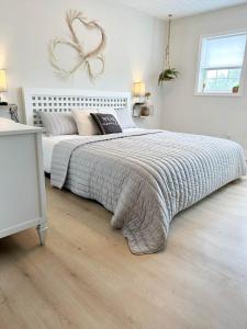 a white bedroom with a large bed with a large comforter at Dreamy Boho Remodeled Cottage with Mountain Views in Sparta