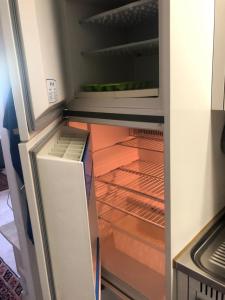 an empty refrigerator with its door open at Laax with indoor and outside pool, sauna, 200 Meter to Ski lift , Fitnessroom, Tennis Place, Joyroom, Parkstadion Reserve in Laax