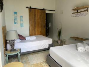 a bedroom with two beds and a table with a lamp at Casa Playa Puerto luz in Santa Marta