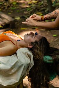 une femme en robe orange reposant sur un banc dans l'établissement Remo Hostel, à Paraty-Mirim