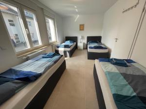 3 camas en una habitación con ventanas en Best Cologne, en Colonia