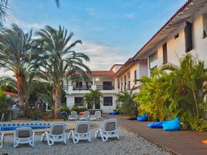 ein Resort mit Stühlen, einem Pool und Palmen in der Unterkunft POSADA RANCHO DELFIN in El Yaque
