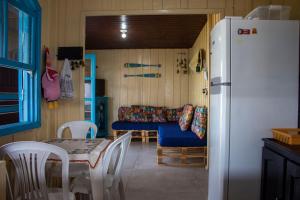 eine Küche mit einem Kühlschrank sowie einem Tisch und Stühlen in der Unterkunft Casa das Ondas in Itapoa
