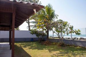Blick auf den Strand von einem Haus mit einem Baum in der Unterkunft Casa das Ondas in Itapoa