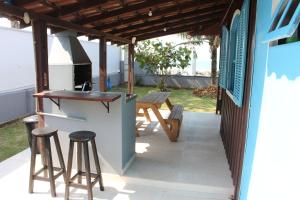 a patio with a bar and a picnic table at Casa das Ondas in Itapoa