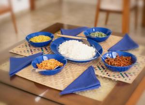 uma mesa com quatro tigelas azuis de arroz e legumes em The Cloud Hanthana, Kandy em Kandy