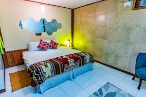 a bedroom with a bed and a blue chair at La Casa del Molino Blanco B&B in Baños