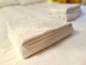 einen Stapel weißer Handtücher auf einem Bett in der Unterkunft Champex Apartments in Pré-Saint-Didier