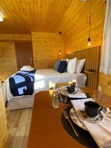 una habitación de hotel con una cama y una mesa con platos en Chalés Canto da Serra en Monte Verde