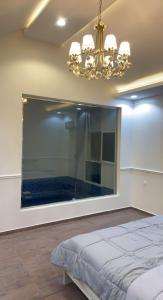 Schlafzimmer mit einem großen Fenster und einem Bett in der Unterkunft شاليه القمر في بهر in Ar Rawḑah