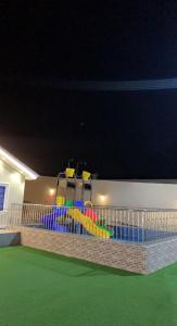 ein Spielplatz in einem Haus in der Nacht in der Unterkunft شاليه القمر في بهر in Ar Rawḑah