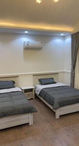 dwa łóżka siedzące obok siebie w pokoju w obiekcie شاليه القمر في بهر w mieście Ar Rawḑah