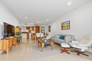 ein Wohnzimmer mit Sofa und Tisch in der Unterkunft Cotton Beach Resort - Holiday Management in Kingscliff