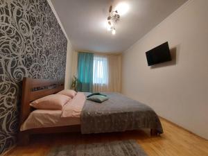 a bedroom with a bed and a tv on a wall at Трикімнатні апартаменти біля Порт Сіті in Lutsk