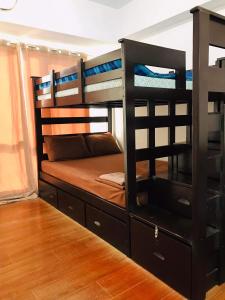 a bedroom with bunk beds and a wooden floor at Abreeza chills place 1815 in Davao City