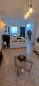 ein Wohnzimmer mit einem weißen Sofa und einem Glastisch in der Unterkunft Duplex cómodo y elegante zona alta de Mendoza in El Challao