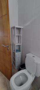 La salle de bains est pourvue de toilettes blanches et d'une porte en bois. dans l'établissement Duplex cómodo y elegante zona alta de Mendoza, à El Challao 12 autres photos