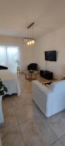 ein Wohnzimmer mit einem Bett, einem Sofa und einem TV in der Unterkunft Duplex cómodo y elegante zona alta de Mendoza in El Challao