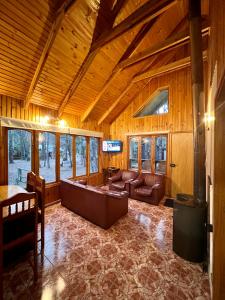 una sala de estar con un sofá y una mesa en Cabañas Bosque las Trancas, en Las Trancas 37 fotos más