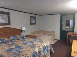 a hotel room with a bed and a bath tub at Kensington Inn - Howell in Howell