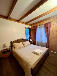een slaapkamer met een bed met twee handdoeken erop bij Cabañas Bosque las Trancas in Las Trancas