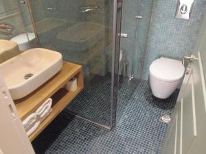a bathroom with a shower and a sink and a toilet at Atlantica Yakinthos in Kato Daratso