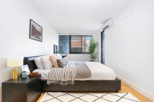 a bedroom with a bed and a desk and a window at Urban Retreat in Surry Hills l 2 Bedroom Property with Parking in Sydney