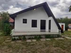 a small white house with a black roof at Apartman Vidikovac in Varna