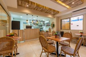 a restaurant with tables and chairs and a kitchen at Hotel Stay Here Suites in Santo Domingo