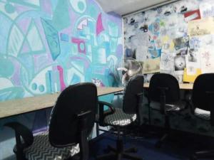 una stanza con sedie e tavolo e un muro con graffiti di Casa Copada a Montevideo