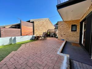 a patio with a wooden deck next to a brick building at DRUM8- 3 Bed townhouse Drummoyne in Sydney