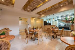 a restaurant with tables and chairs and a kitchen at Hotel Stay Here Suites in Santo Domingo