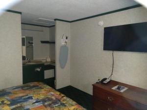 a bedroom with a bed and a tv on the wall at Kensington Inn - Howell in Howell