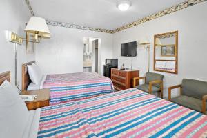 Cette chambre comprend 2 lits et une télévision. dans l'établissement Friendship Inn Hotel, à Killeen