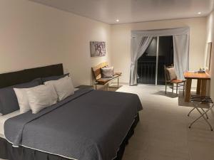 een slaapkamer met een bed, een tafel en stoelen bij LOP Inn San Jose Aeropuerto - Costa Rica in Ciudad Cariari +17 foto's