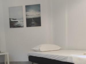 a white bedroom with two pictures on the wall at Villa Rodanthi Sivota in Syvota