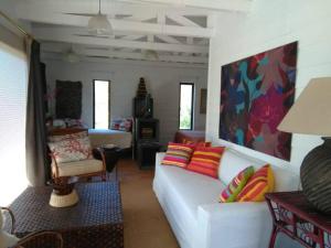 sala de estar con sofá blanco y almohadas coloridas en Cabaña Loft Campo y Mar Rocas de Santo Domingo, en Santo Domingo