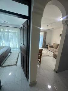 - un salon avec une porte et un canapé dans l'établissement Grey Pearl Apartments Where Raha is Also Our Priority, à Malindi