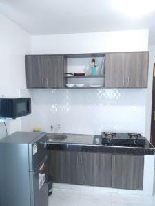 a kitchen with a refrigerator and a stove at Grey Pearl Apartments Where Raha is Also Our Priority in Malindi