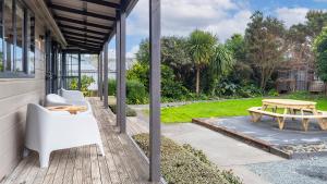 a patio with a picnic table and a bench at Matakana Village Central - Modern Holiday Home in Matakana