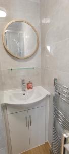 La salle de bains est pourvue d'un lavabo blanc et d'un miroir. dans l'établissement Comfy 2 bedroom Apt in central location, Newly Refurbished, à Plymouth