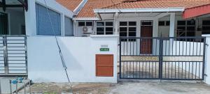 a white house with a gate and a red door at ADIMA Homestay in Kuala Terengganu